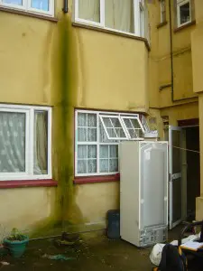 image of damp on side of a house from guttering defect